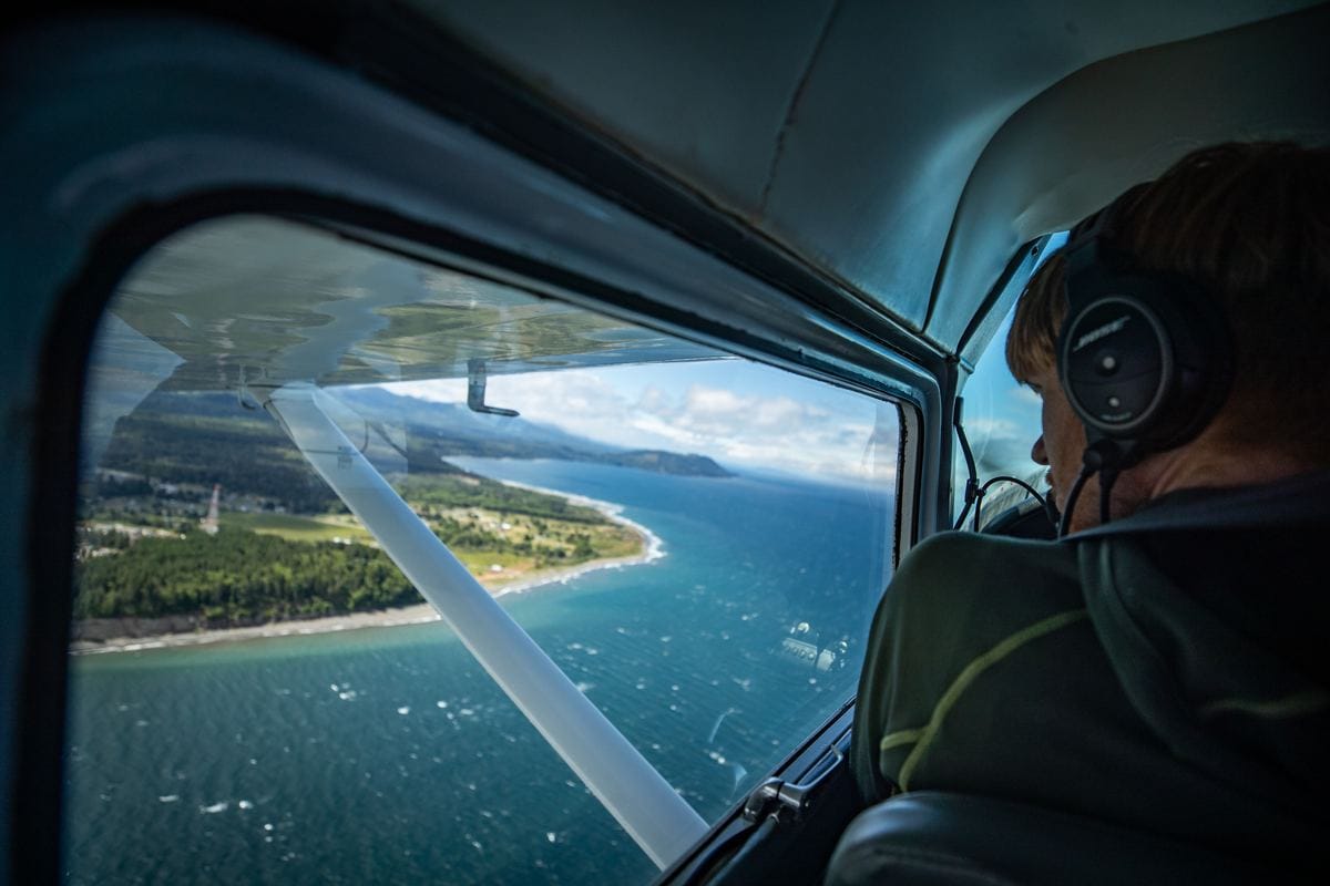 A passenger in a headset looking out the window on a Citizen Air flight